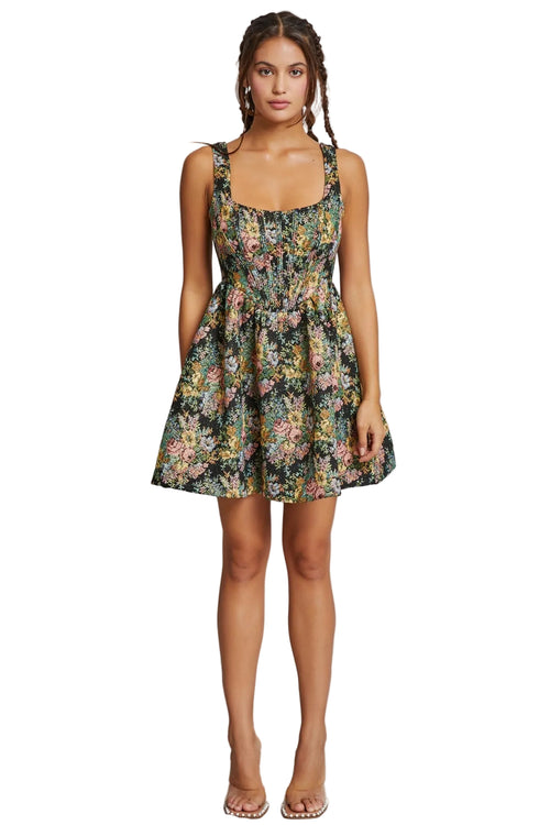 Woman wearing a floral dress against a plain background