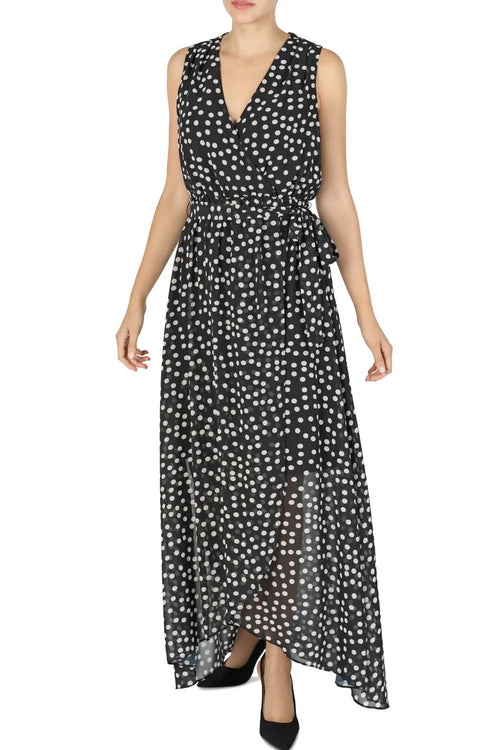 Woman wearing a black sleeveless dress with white polka dots on a white background