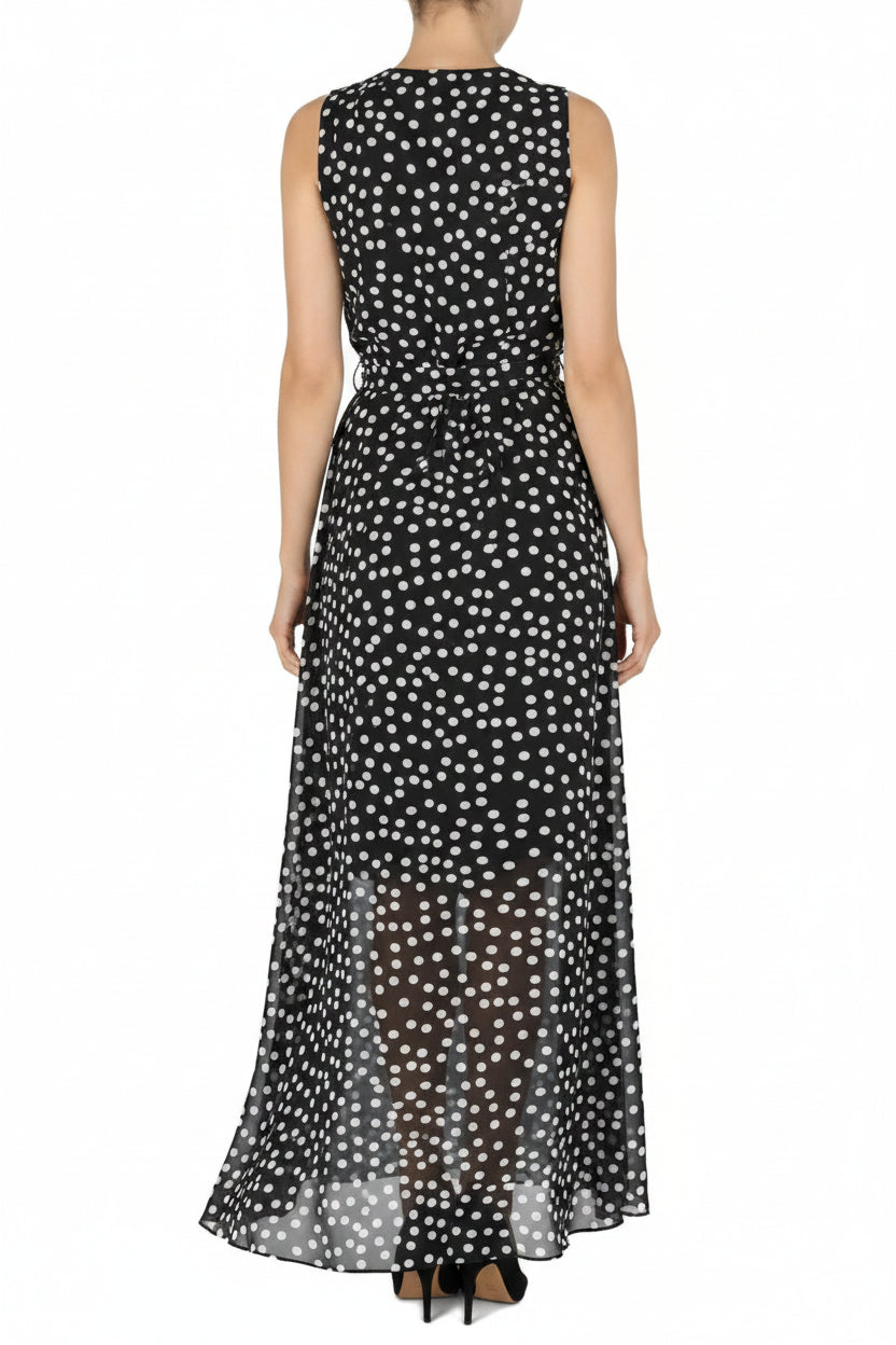 Woman wearing a black sleeveless dress with white polka dots on a white background
