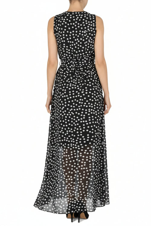 Woman wearing a black sleeveless dress with white polka dots on a white background