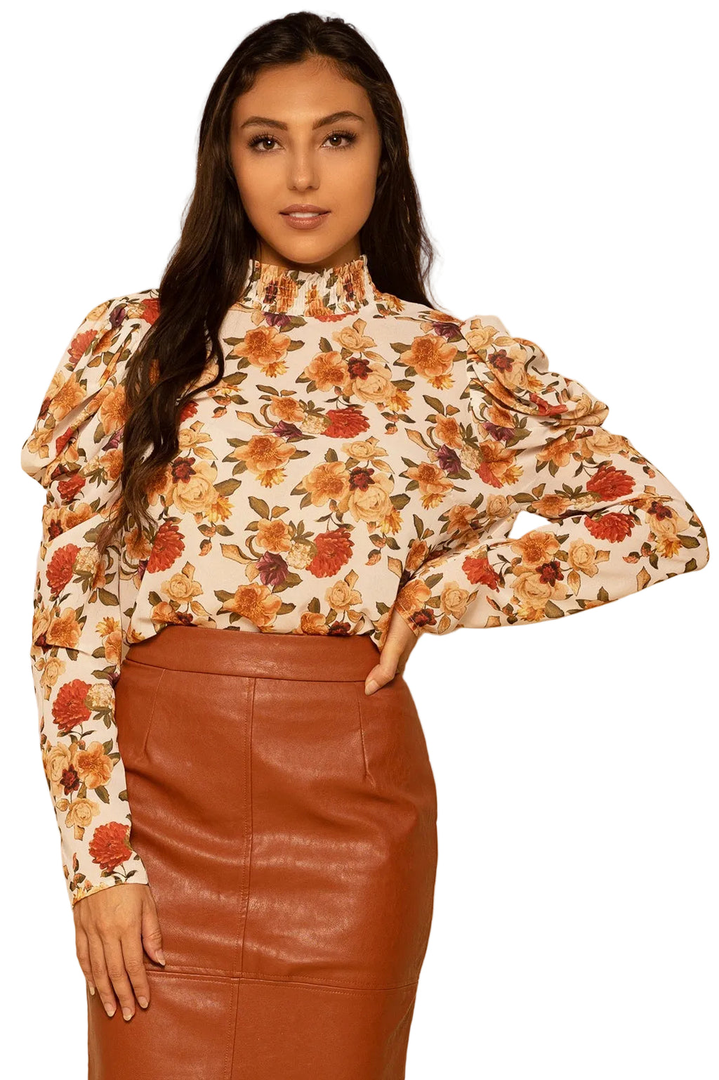 Woman wearing a floral blouse and brown leather skirt against a beige background