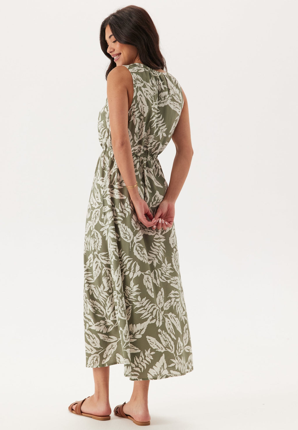 Woman wearing a green leaf-patterned dress on a white background