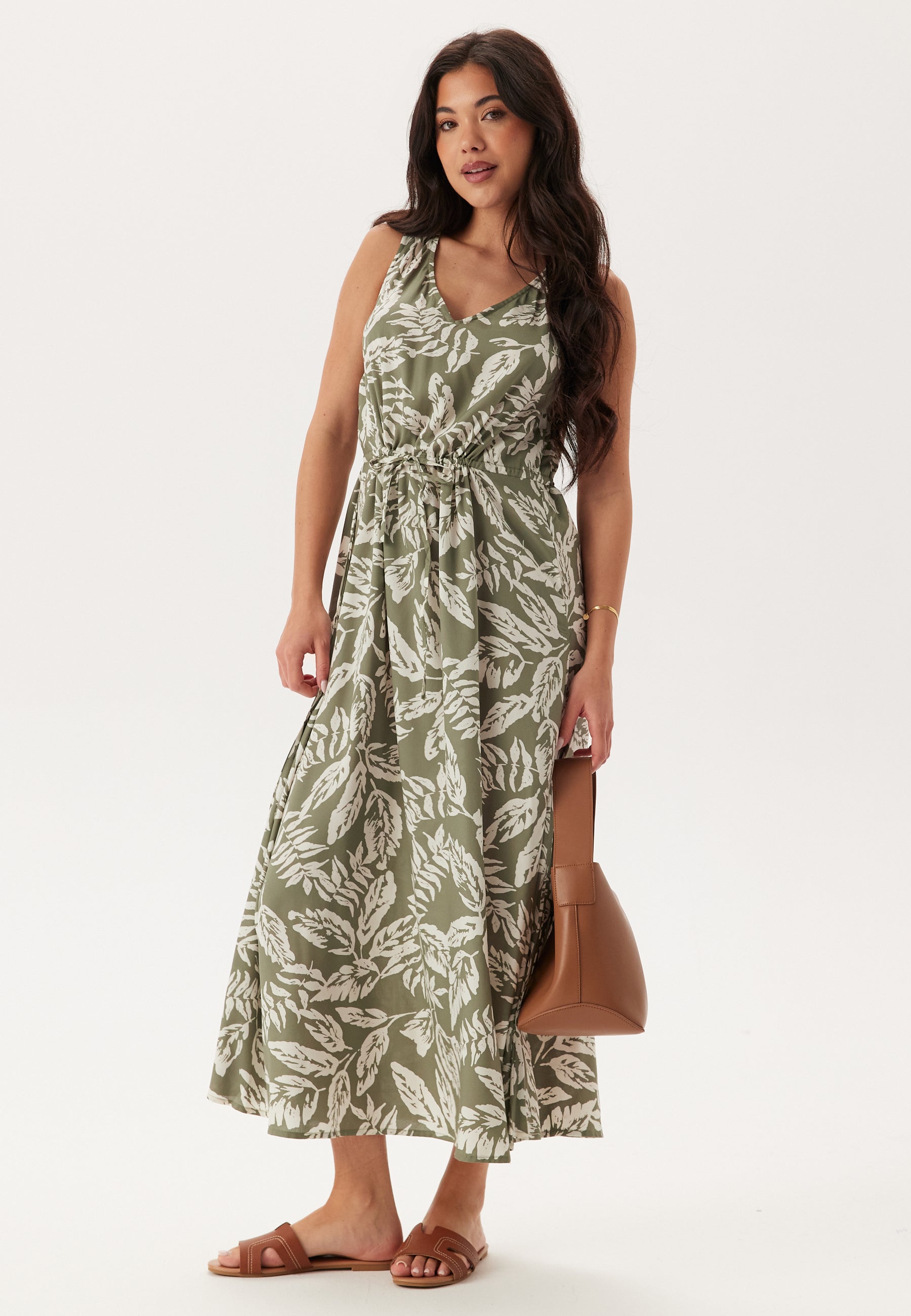 Woman wearing a green leaf-patterned dress on a white background