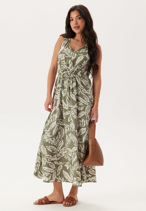 Woman wearing a green leaf-patterned dress on a white background