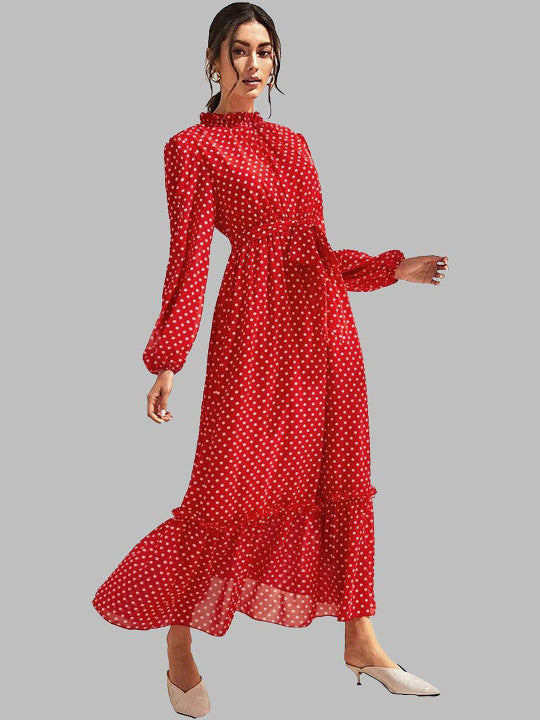 A woman modeling a long-sleeve red maxi dress with a white polka dot pattern, featuring a high ruffled collar, a defined waist, and a tiered ruffle hem, paired with beige pointed-toe mule heels against a solid gray background.