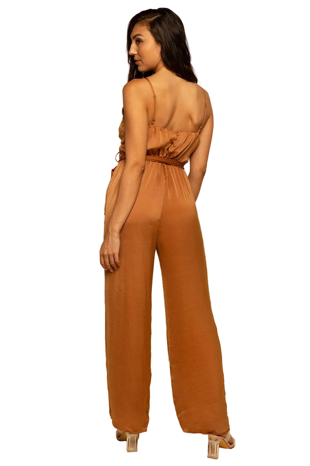 Woman wearing a brown jumpsuit on a beige background