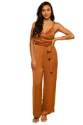Woman wearing a brown jumpsuit against a beige background