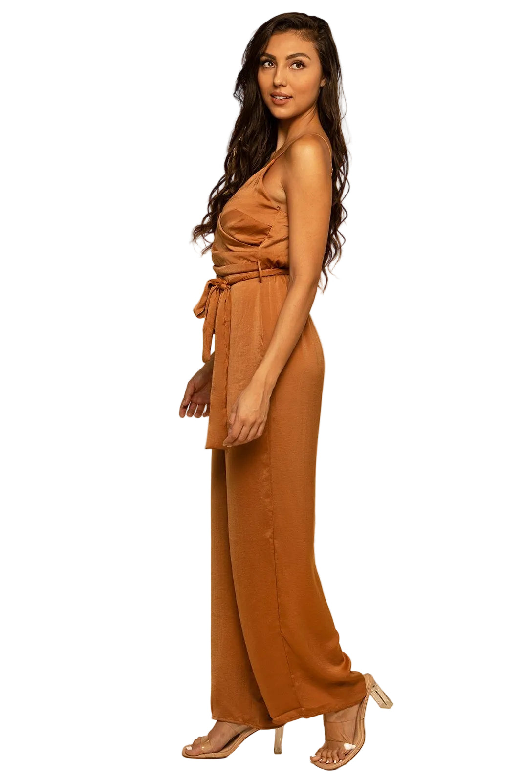 Woman wearing a brown jumpsuit against a beige background