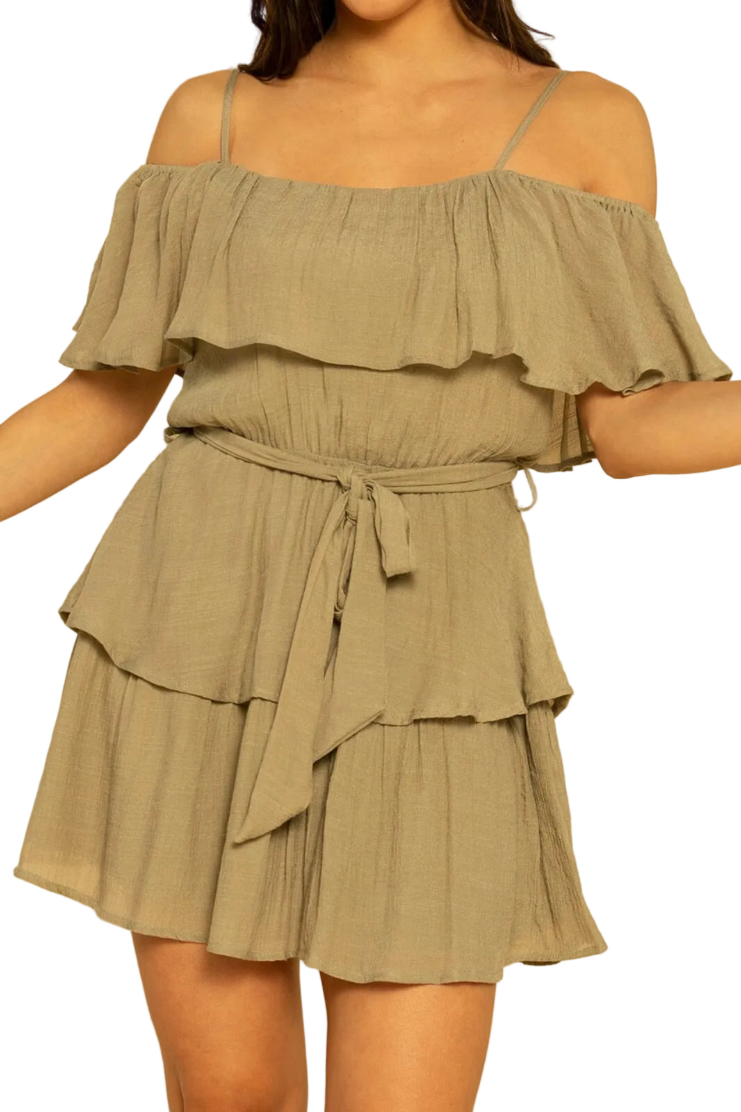 Woman wearing a green off-shoulder dress with ruffled layers on a beige background